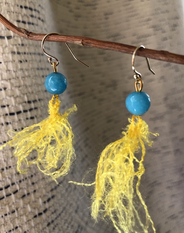 Turquoise colored, semi precious gem stones knotted on yellow silk. Hung on GF earring hooks.