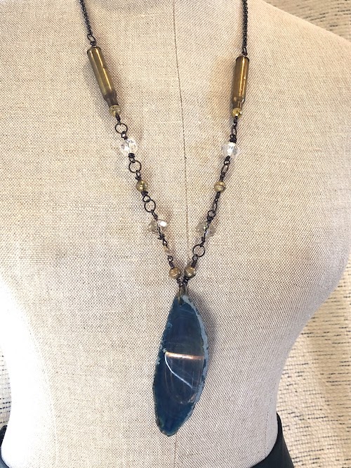 Blue agate pendant with .223 ammo casings wire wrapped with crystals on brass chain.
