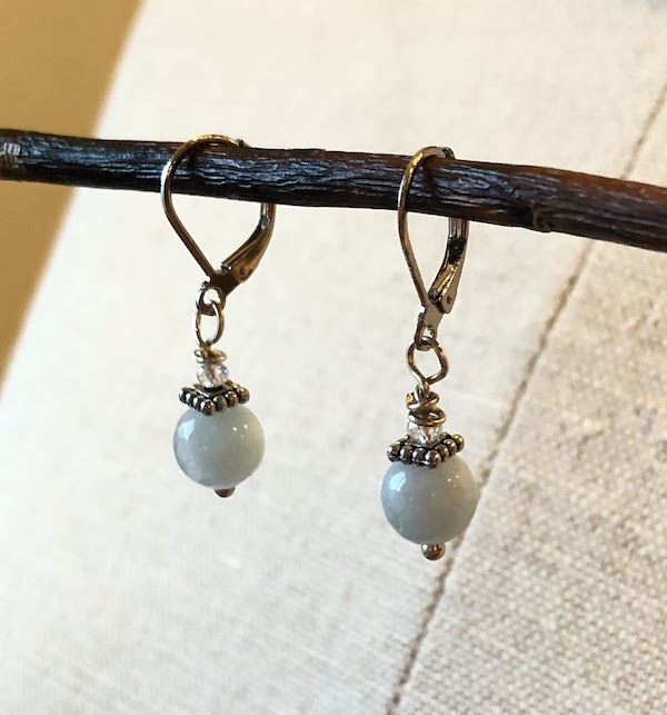 Light blue colored, semi precious gem stones wire wrapped with a crystal bead. All hardware is stainless steel and plated sterling.