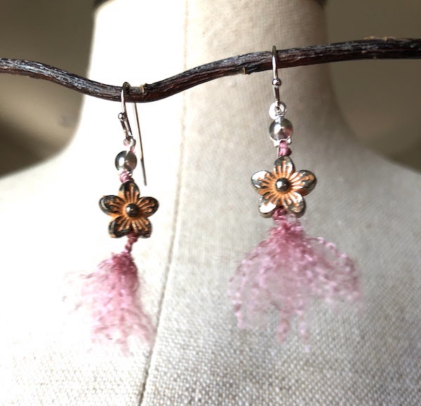 Orange metal flower beads knotted on 100% pink silk and fluffed out!