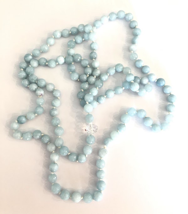 Amazonite faceted gemstone necklace, hand knotted on white silk and has one clear crystal bead. Necklace is continuously knotted without a clasp.