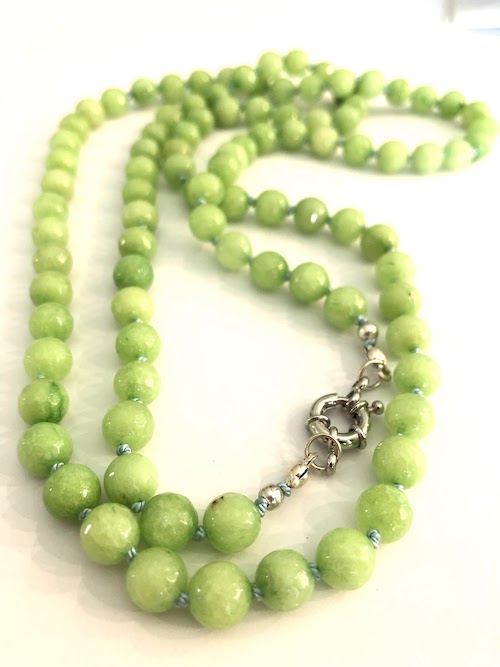 Lime green, faceted jade gemstone necklace, hand knotted on pale blue silk and finished with silver clasp.