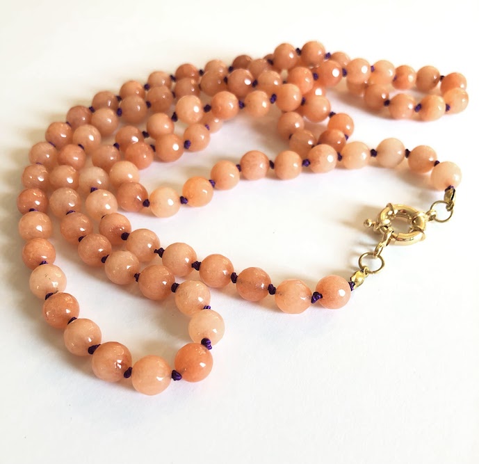 Orange, faceted jade gemstone necklace, hand knotted on royal purple silk and finished with gold clasp.