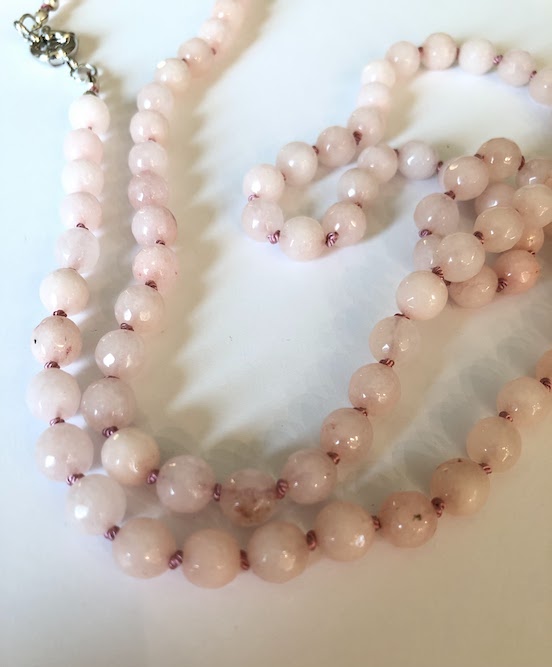 Pale colored pink, faceted jade necklace, hand knotted on light rose silk and finished with silver clasp.