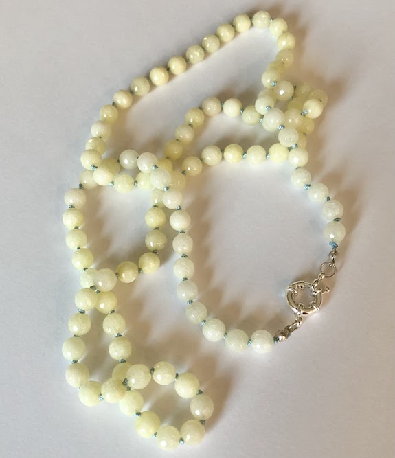 Pale yellow, faceted jade gemstone necklace, hand knotted on light blue silk and finished with silver clasp.
